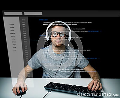 Man in headset hacking computer or programming Stock Photo