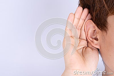Man hearing loss or hard of hearing and cupping his hand behind his ear isolate grey background, Deaf concept Stock Photo
