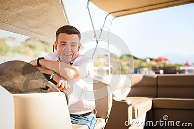 Man helm boat on pier. tours on water Stock Photo