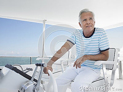 Man At The Helm Of Luxury Yacht Stock Photo
