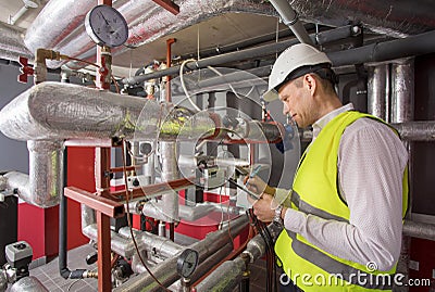 Man in helmet writing down measurements in heat Stock Photo