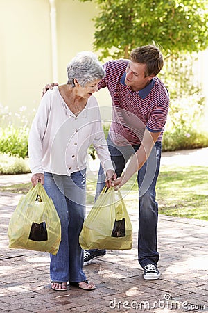 Man Helping Senior Woman With Shopping Stock Photo