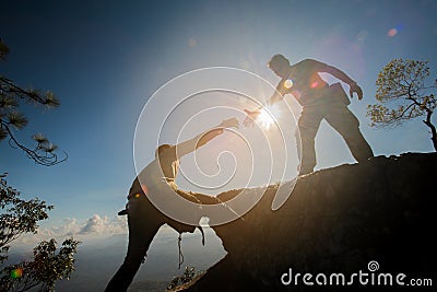 Man helping to climb the rock Stock Photo