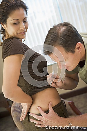 Man helping woman inject drugs to achieve pregnanc Stock Photo