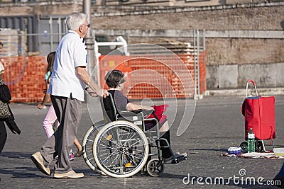 Man and her disabled wife in the wheelchair Editorial Stock Photo