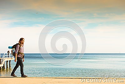 Man hiker with backpack tramping by seaside Stock Photo