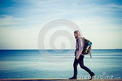 Man hiker with backpack tramping by seaside Stock Photo