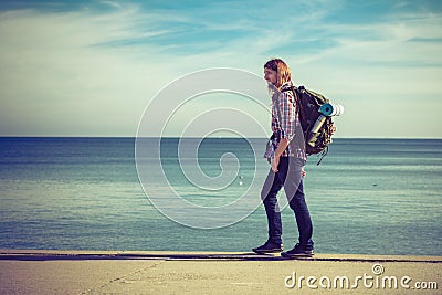 Man hiker with backpack tramping by seaside Stock Photo