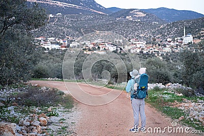 Man hiking in mountains,carrying baby in bacpack,sling,carrier.Family travelling,trips,lifestyle.Father,child,infant Stock Photo
