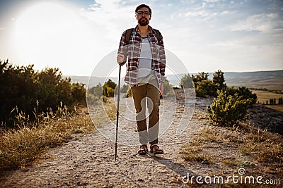 Man hiking in the mountains using pole and looking away Stock Photo