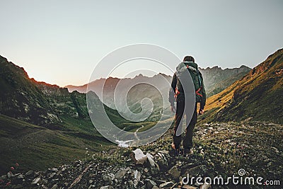 Man hiking at sunset mountains with heavy backpack Stock Photo