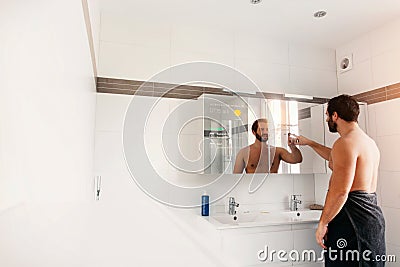 Man in his bathroom touching his smart mirror Stock Photo