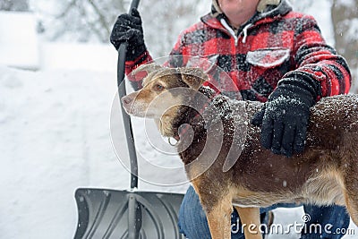 Man and his dog shoveling snow Stock Photo