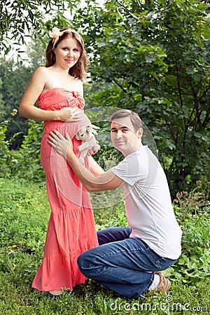 Man and his pregnant wife have fun in the park Stock Photo
