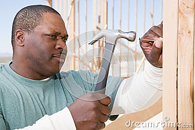 A man hitting a nail with a hammer Stock Photo