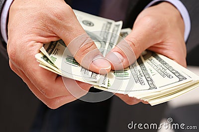 Man hold in arm pack of hundred dollar bills Stock Photo