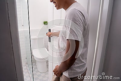 Man hold his genitals to pee Stock Photo