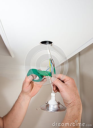 Man is holding adhesive tape in his hands. Electrical insulator for light bulb. Maintenance repair works in the flat. Restoration Stock Photo