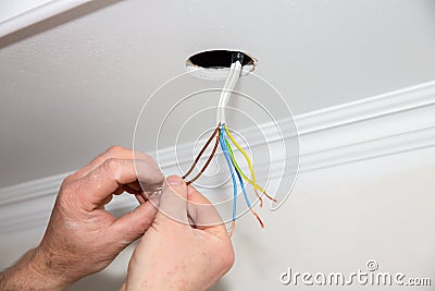 Man is holding adhesive tape in his hands. Electrical insulator for light bulb. Maintenance repair works in the flat. Restoration Stock Photo