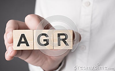 Man holding agr word on wooden cube Stock Photo