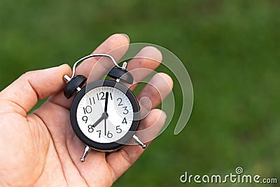 Man holding an alarm clock in hands Stock Photo