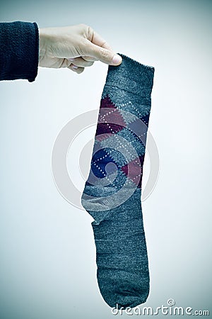 Man holding an argyle patterned sock, vignetted Stock Photo