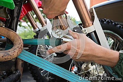 Man holding blue tie-down strap buckle that is used to secure mo Stock Photo