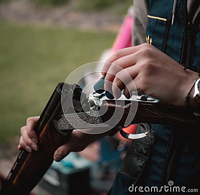 Man holding a break open double barreled shotgun. Shooting clay disks as a sport in the uk. Beautiful wooden engraved masterpiece Stock Photo