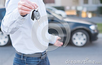 Man holding a car key next to vehicle Stock Photo