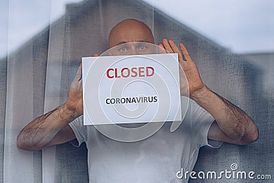 Man holding card shop closed due to coronavirus epidemic. Stock Photo