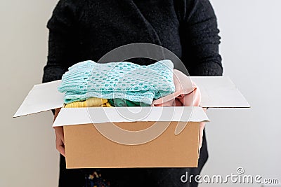 Man holding a clothes donate box. Donation concept. Stock Photo