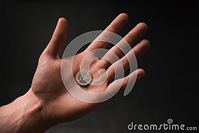 Man holding a coins. Euro currency on a black background. HandÂ´s of young man holding a money. Finance and banking concept. Stock Photo