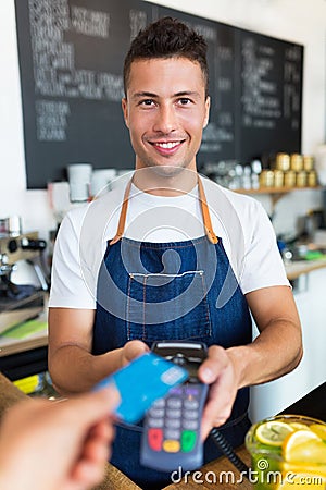 Man holding credit card reader at cafe Stock Photo