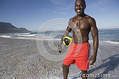 Man Holding Football On Beach Stock Photo