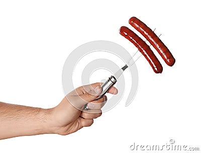 Man holding fork with grilled sausages on white , closeup. Barbecue food Stock Photo