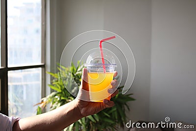 Man holding Fresh Juice drink in hand in office white background shoot concept Stock Photo