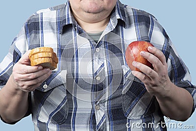 A man is holding groceries in his hands.Diet. Obesity.The disease is overeating Stock Photo