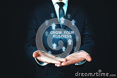 Man holding Grow Your Business words with growth arrows. Stock Photo