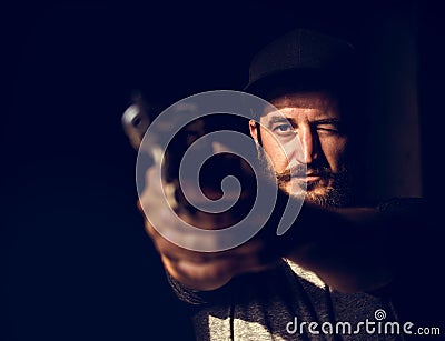 Man holding a gun wth black background Stock Photo