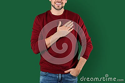 Man holding hand near his heart on color background Stock Photo