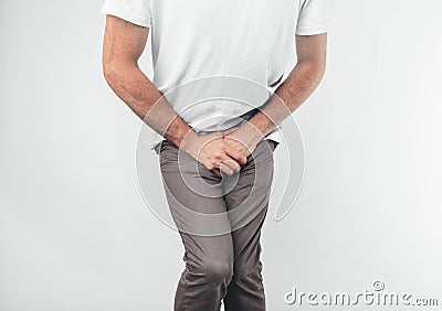 A man holding his penis with on the white background. Wants to go to the toilet. Stock Photo