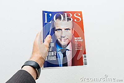 Man holding L`Obs magazine newspaper with Emmanuel Macron on fir Editorial Stock Photo