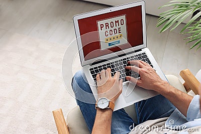 Man holding laptop with activated promo code indoors, above view Stock Photo