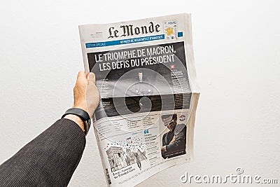 Man holding Le Monde newspaper with Emmanuel Macron on first page cover Editorial Stock Photo