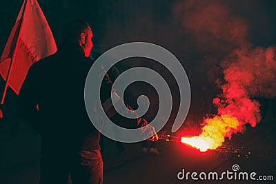 Man holding a lit fire torch during the nationalistic march of Independence day of Poland Editorial Stock Photo