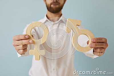 Man holding male and female gender symbols showing concept of sexuality and relationship Stock Photo