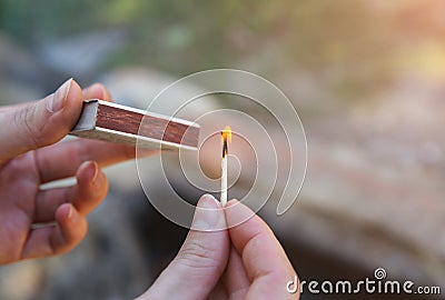 Man is holding matches in hands. Person is making fire outdoors Stock Photo