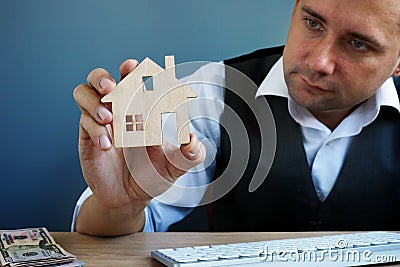 Man holding model of home. Property investment and house mortgage Stock Photo