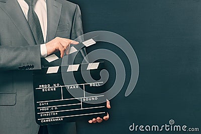 Man holding movie clapper board on black Stock Photo