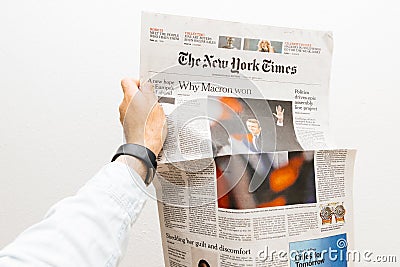 Man holding the new york times newspaper with Emmanuel Macron on Editorial Stock Photo